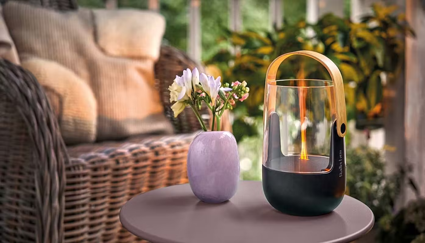 Stadler Form Sophie little aroma diffuser and latern on a terrace with lots of flowers